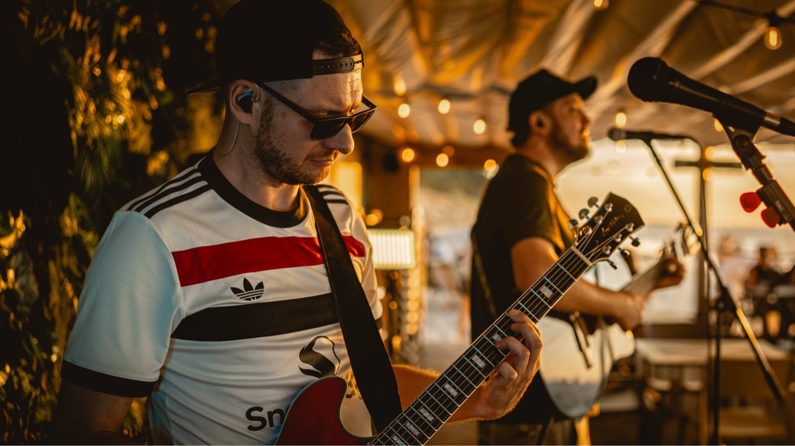 Letni Set - gitarzysta na plenerowym koncercie przy ciepłym świetle